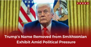 An official setting with a man in a suit addressing the media, standing before national flags and an official seal, discussing the Smithsonian exhibit decision where Trump’s name removed.