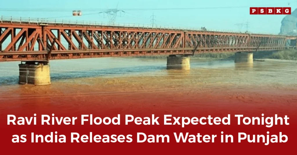 A metal bridge over a swollen muddy river under a clear sky, warning of potential Ravi River flood after dam water release.