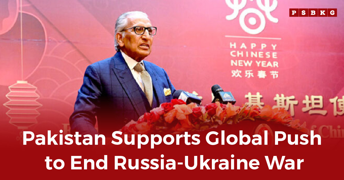 A speaker at a flower-decorated podium addresses an audience with a Chinese New Year backdrop, linking to Pakistan Russia Ukraine war stance.