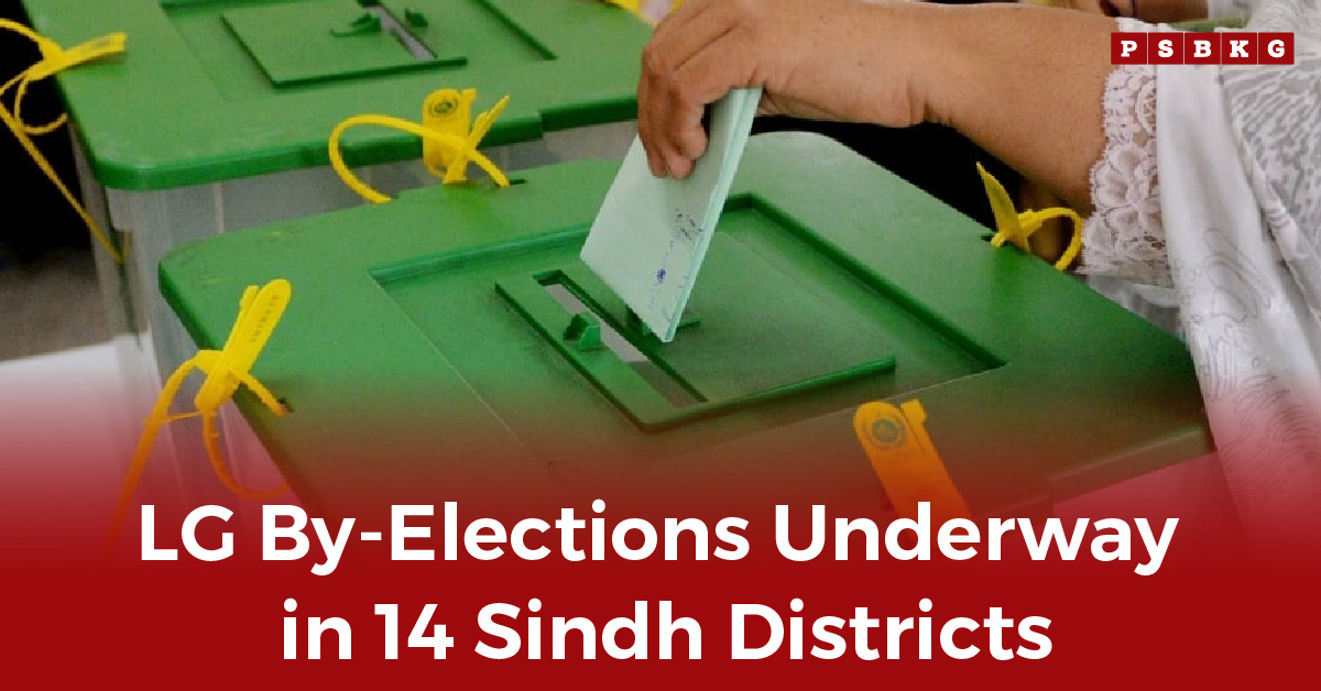 A voter casts a ballot into a green election box during Sindh LG by-elections in Pakistan.
