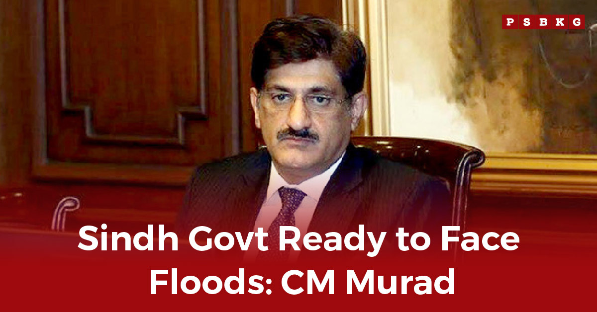 Sindh govt flood preparedness A formal setting with a man in a suit sitting at a desk, discussing flood preparedness for Sindh. Background features wood paneling and artwork.