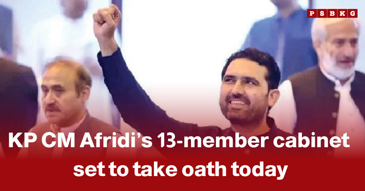 A group of individuals gathered at an oath-taking ceremony, with one person raising a fist in celebration, marking KP CM Afridi’s new 13-member cabinet taking oath KP cabinet oath.