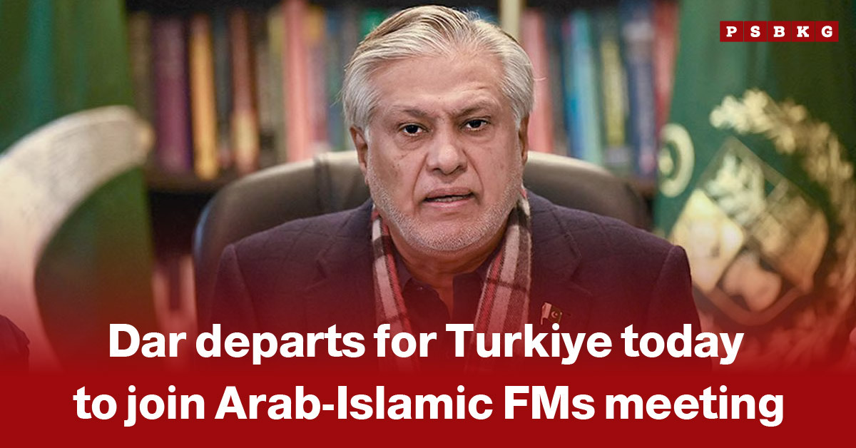 A man in formal attire seated against a backdrop of books and national flags, preparing to depart for Turkiye to attend a meeting of Arab-Islamic foreign ministers, Dar Turkiye visit.