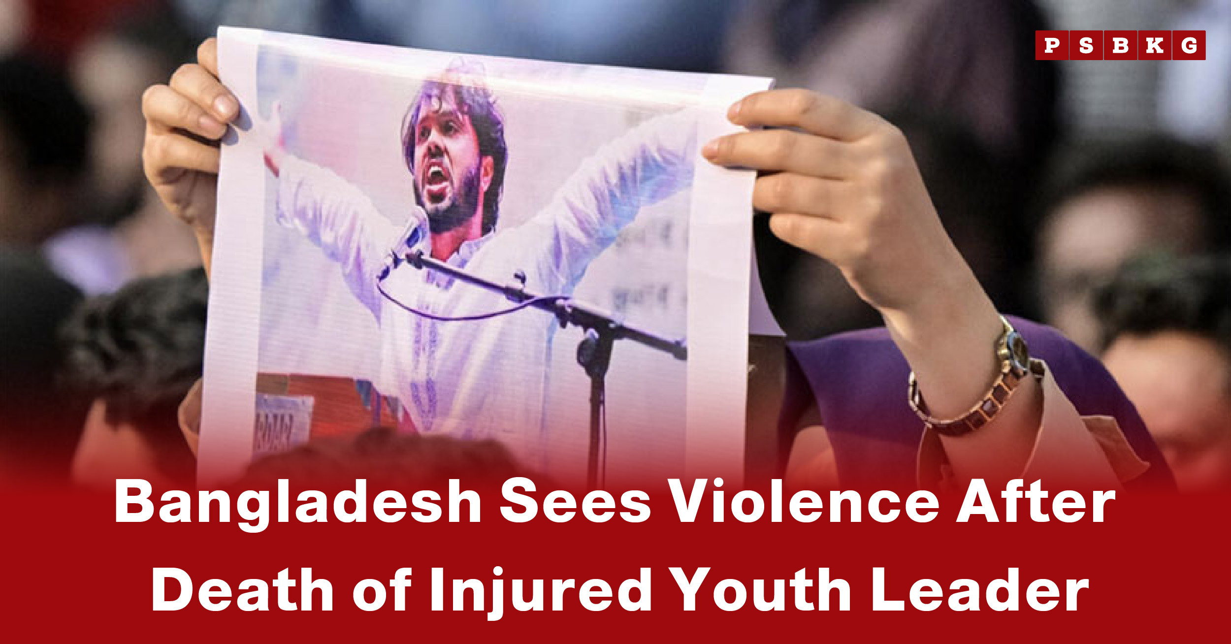 A person holds a poster of a youth leader during a rally, highlighting Bangladesh violence youth leader amid unrest following his death.