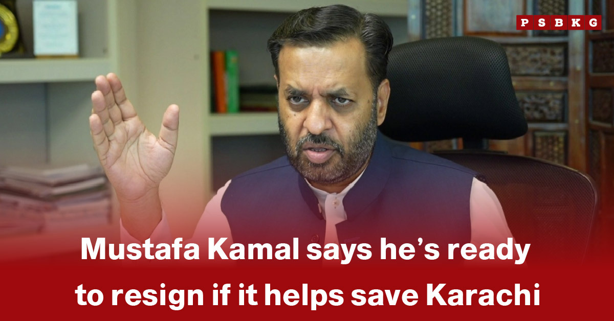 A man gestures while discussing Mustafa Kamal ready to resign for the betterment of Karachi, seated in an office setting.