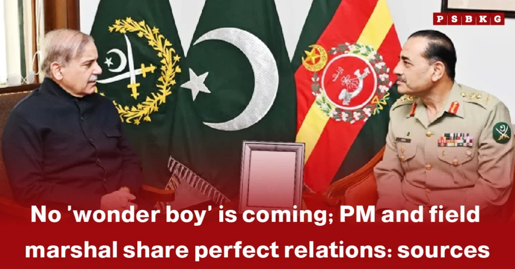 Two men sit at a table in front of flags representing Pakistan and the army, discussing PM and field marshal relations with a framed photo in the background.