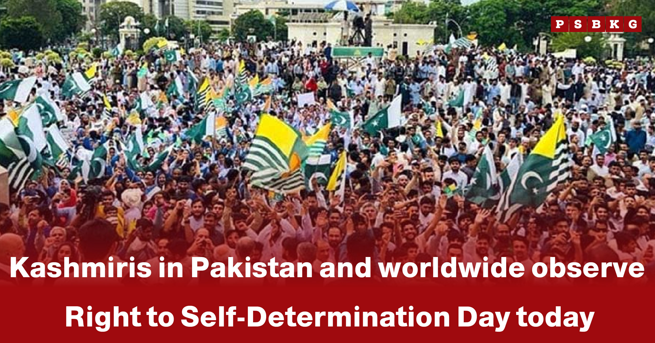 A large crowd waves flags while gathering to observe Self-Determination Day Kashmir in Pakistan and around the world.