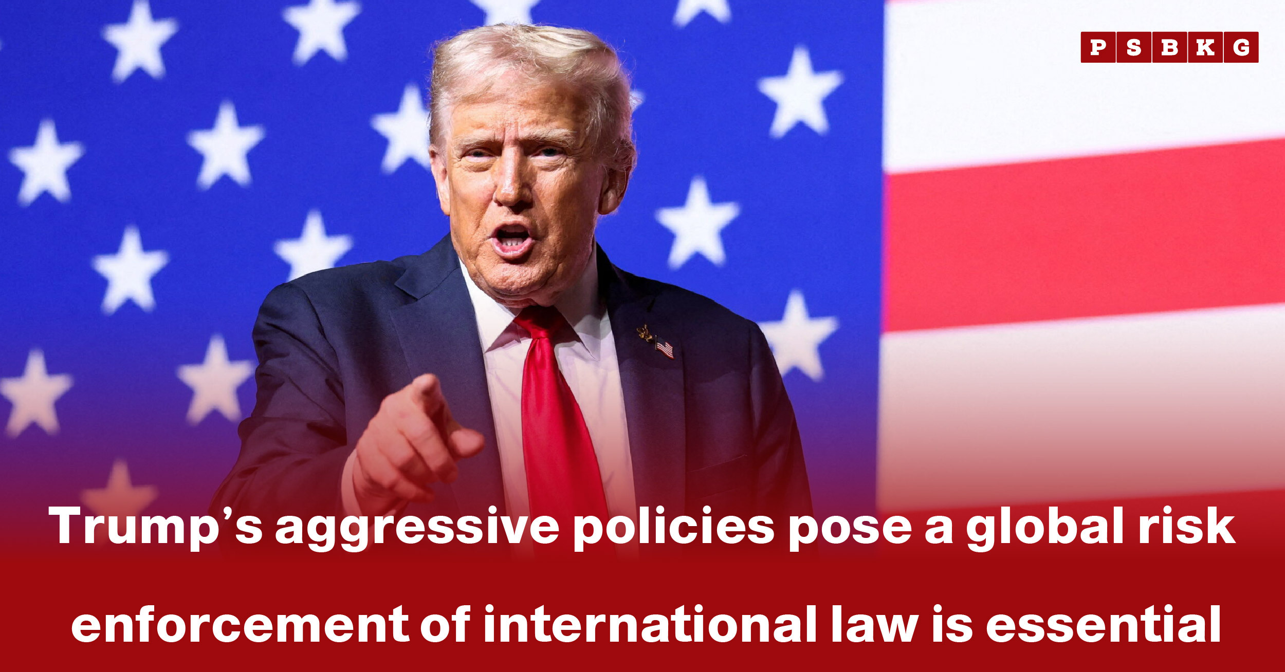 A speaker gestures emphatically against a backdrop of red, white, and blue stars, highlighting Trump aggressive policies global risk and the importance of enforcing international law.