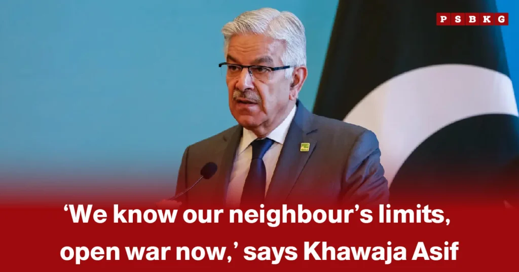 Khawaja Asif open war statement: A man speaks at a podium discussing tensions with a neighboring country, with a blurred face and a large national flag in the background.