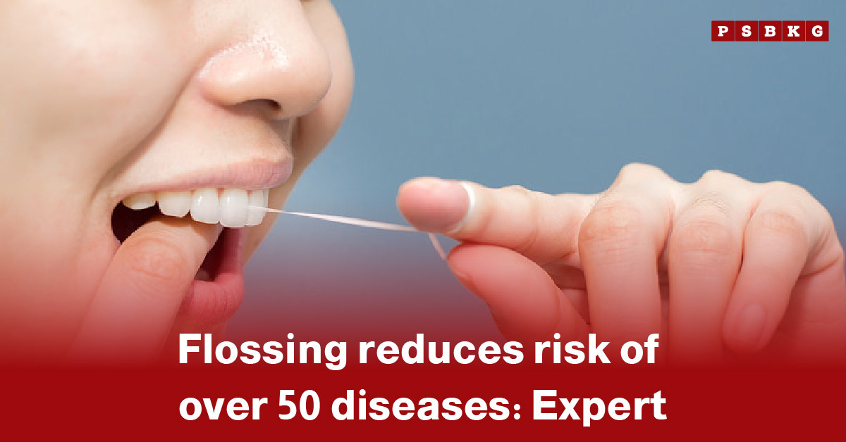 flossing reduces disease risk: Close-up of a hand holding dental floss against a blue background, emphasizing proper dental hygiene.