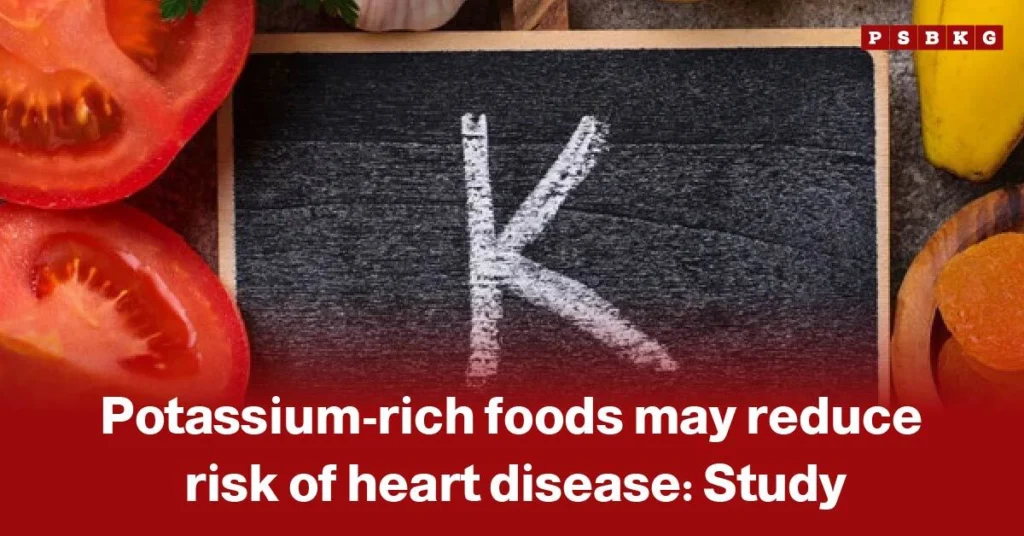 Chalkboard with the letter K surrounded by fresh potassium-rich foods like tomatoes, garlic, banana, and orange slices, highlighting potassium-rich foods heart health and their benefits according to a study.