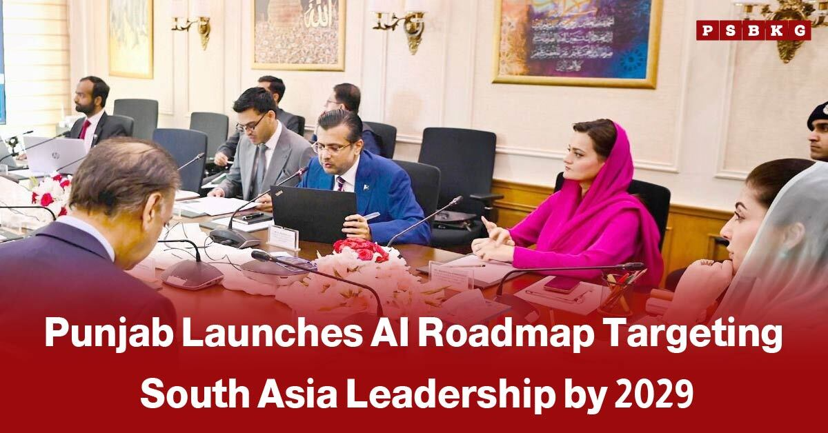 A group of people in a formal meeting, with a man in a blue suit speaking and a woman in bright pink listening, illustrating Punjab AI roadmap 2029 aiming to lead South Asia in artificial intelligence by 2029.
