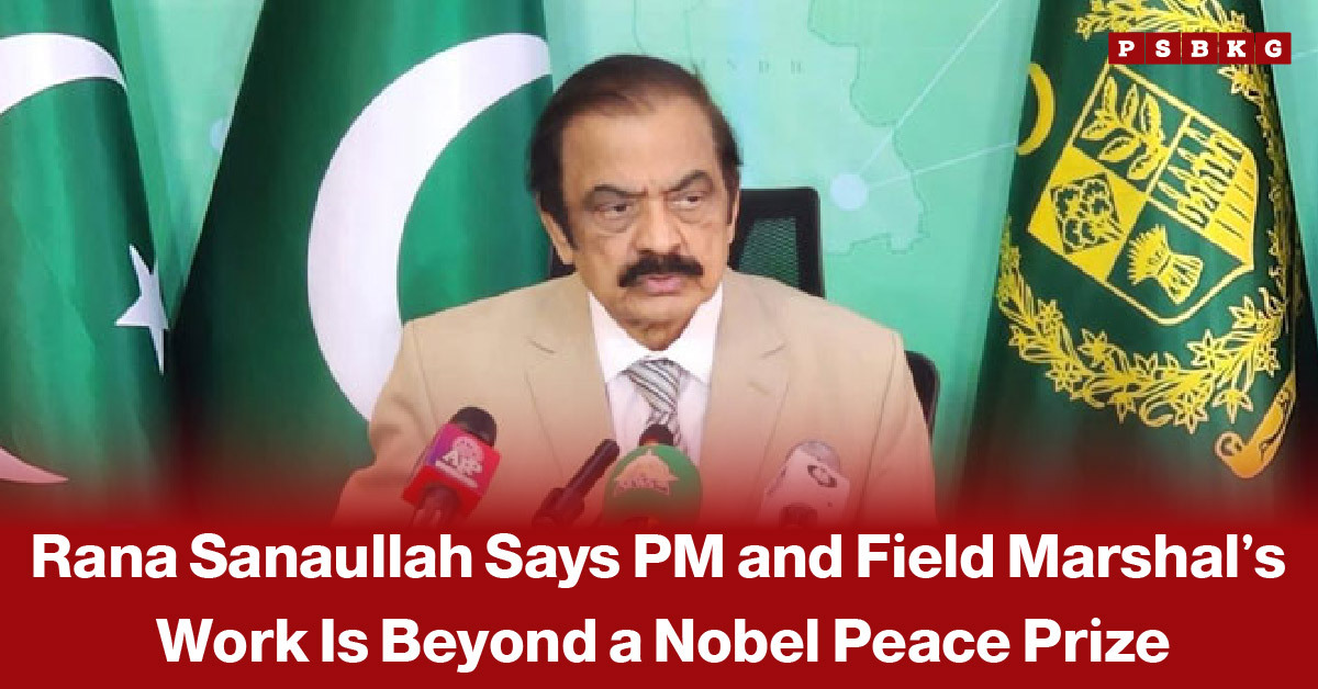 Person in a beige suit speaking during a press conference, with Pakistan’s flags and official emblem visible in the background, accompanied by a news-style headline about Rana Sanaullah’s statement regarding the Nobel Peace Prize.