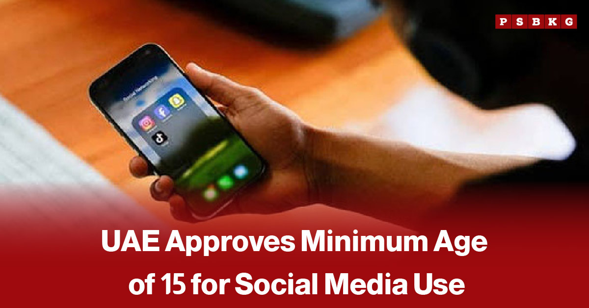 Person holding a smartphone showing social media apps on the screen, with an overlaid news-style text about the UAE approving a minimum age of 15 for social media use.