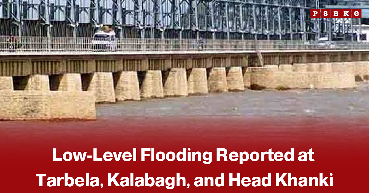 Large dam with water flowing through its spillways and vehicles crossing the bridge above, accompanied by a news-style headline about low-level flooding reported at Tarbela, Kalabagh, and Head Khanki.